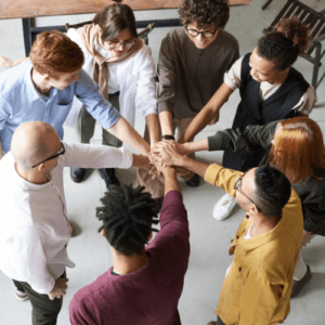 personnes en ronde qui se tiennent par la main pour les lever au ciel. Pouvoir et force du collectif